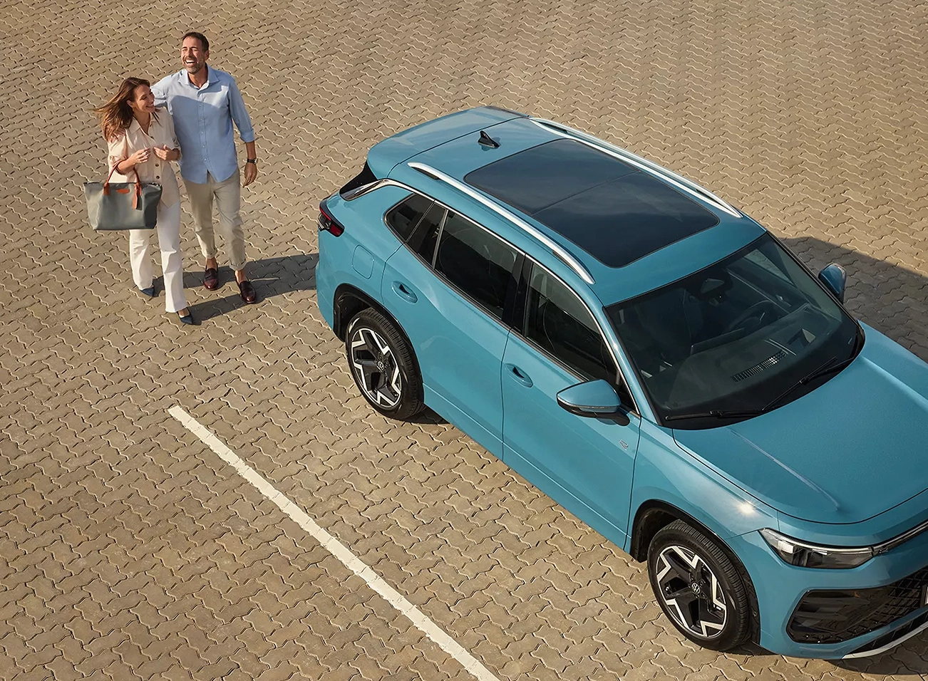 Novo Tiguan R-Line azul visto de cima com pessoas ao lado
